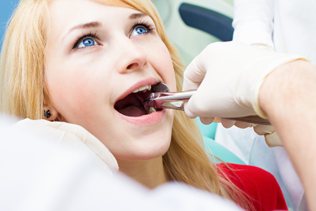 A woman receiving dental treatment with a dentist s assistance.