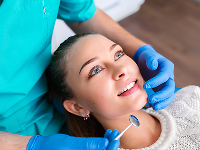 A woman receiving dental care from a professional, with a smiling expression.